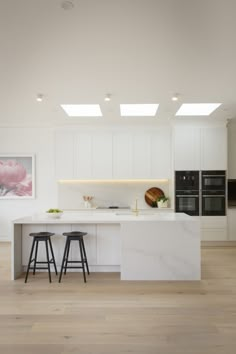 a kitchen with two stools next to an island