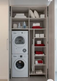 a washer and dryer are in the closet next to each other, which is also open