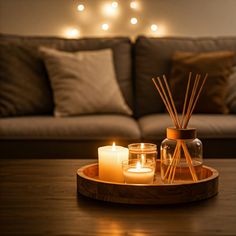 candles are sitting on a tray in front of a couch