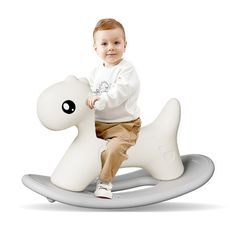 a little boy sitting on top of a white rocking horse