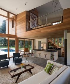 a living room filled with furniture next to a swimming pool on top of a wooden floor