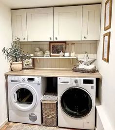 a washer and dryer in a small room with white cabinets on the wall