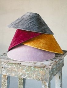 three different colored hats sitting on top of an old stool