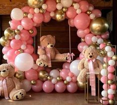 there are balloons and teddy bears in front of the balloon arch that is decorated with pink, gold and white balloons