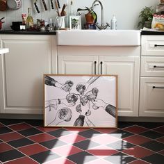 a kitchen scene with focus on the framed artwork