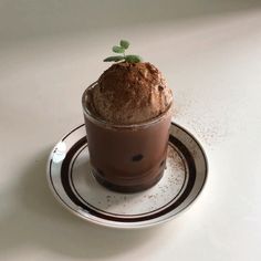 a cup filled with ice cream sitting on top of a plate