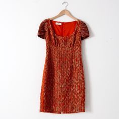 A Pre-Owned Prada Dress. The Wool Blend Tweed Dress Features A Fitted Bodice With Knit Cap Sleeves, And A Pencil Skirt With Vented Back. It Zips Closed. It Is Marked Size 42. Made In Italy. It Is 54% Virgin Wool, 39% Cotton, 5% Mohair, 1% Other Fibers. The Sleeve Are 100% Wool. The Bust Measures 37 Inch. The Waist Measures 30 Inch. The Hips Measure 38 Inch. The Length Measures 37 Inch. The Shoulders Measure 13 Inch. The Outside Of The Sleeve Measures 7.75 Inch. It Is In Good Condition. Fitted Knee-length Tweed Dress For Cocktail, Fitted Red Tweed Dress For Work, Elegant Fitted Red Tweed Dress, Fitted Red Tweed Dress, Prada Dresses, Prada Dress, Tweed Dress, Knit Cap, Wiggle Dress