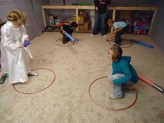 several children are playing with toys in a play room while adults watch from the floor