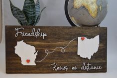 a wooden sign that says,'friends know no distance'with two hearts attached to it