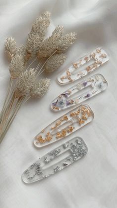 three hair clips sitting next to each other on a white sheet with flowers in it