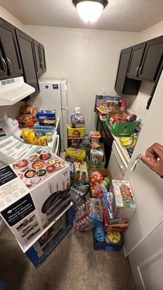 a kitchen filled with lots of food next to a stove top oven and refrigerator freezer