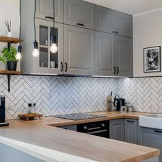 a kitchen with gray cabinets and white tile backsplash