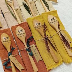 wooden spoons with names on them are lined up next to folded napkins and tags