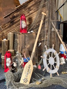 there are many different items on display in this room, including a fishing net and paddles