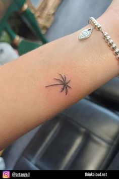 a small palm tree tattoo on the left arm and wrist is shown in black ink