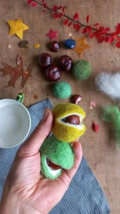 a person holding a stuffed animal in their left hand and some other decorations on the table