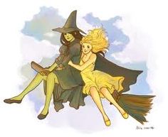 two women dressed as witches riding on a broom