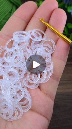 a person holding a pen in their hand next to some rubber rings and a ballpoint pen