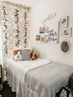 a bedroom decorated with string lights and pictures on the wall, along with a small bed