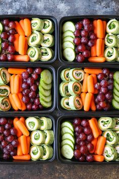 four trays filled with different types of vegetables and fruit arranged in the shape of rolls