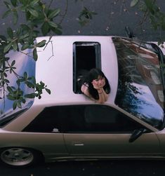 a woman sitting in the driver's seat of a car looking at her reflection