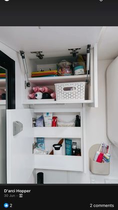 the inside of a small bathroom cabinet with shelves and baskets on it's sides