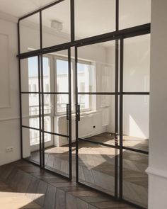 an empty room with glass doors and wood flooring