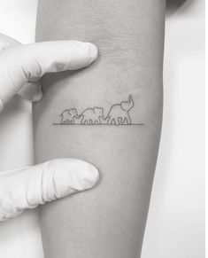 a woman's arm with a line drawing of elephants on the back of it