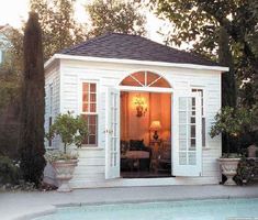 a small white house with a pool in the background