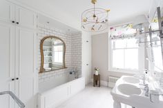 a white bathroom with two sinks and a bathtub in it's center area