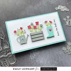 a card with some flowers and a watering can on it, surrounded by cut outs