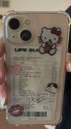 someone holding up a cell phone case with an image of a hello kitty on it