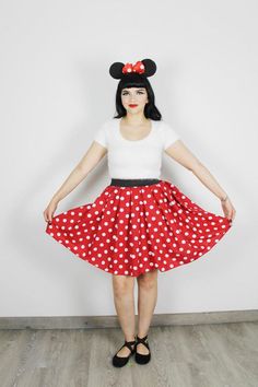 a woman wearing a red and white polka dot skirt with minnie mouse ears on her head