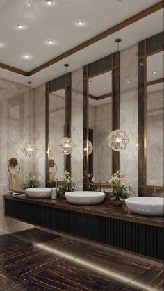 a bathroom with two sinks, mirrors and lights on the wall next to each other