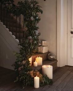 candles are lit on the floor next to a christmas tree