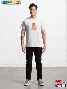 a man standing in front of a white brick wall wearing a t - shirt that says,