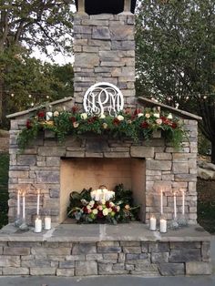 an outdoor fireplace with candles and flowers on it