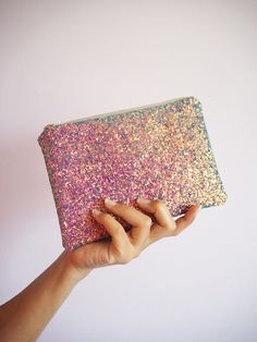 "Glitter Makeup Bag. This glitter makeup bag is made out of a glitter covered sturdy spandex and would be lovely for adding sparkly to your everyday life.  Each bag comes with a beige YKK zip with gold teeth and measures about 7\" x 5\". These would make stunning gifts and add some sparkle. They're small enough to fit inside a bigger handbag and keep all your toiletries and makeup bits safe whilst big enough to use as a small clutch for an evening out.  The inside is a colourful printed cotton t Rainbow Glitter Makeup, Glitter Clutch Bag, Sparkly Makeup, Tissue Paper Wrapping, Glitter Bag, Glitter Clutch, Purple Rainbow, Iridescent Purple, Yellow Glitter