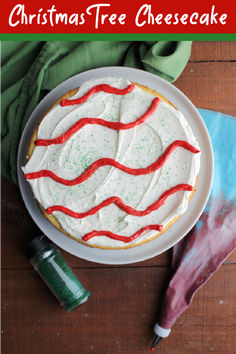 a christmas tree cheesecake with white frosting and red sprinkles on top