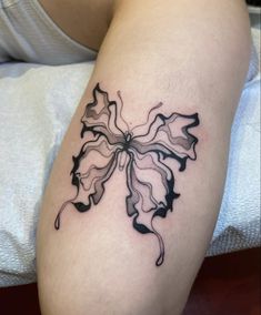 a black and white tattoo on the leg of a woman's arm with leaves