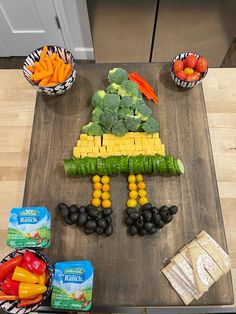 a wooden cutting board topped with fruits and vegetables