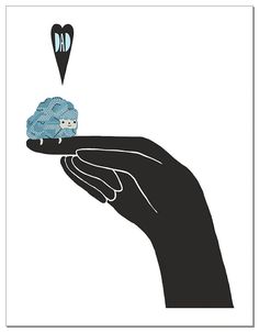 a hand holding a tiny blue object in the shape of a sheep on it's finger