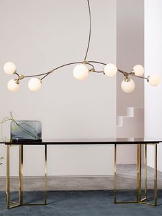 a modern dining table with five lights hanging from it