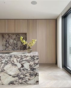 a marble counter top in a room with wood paneling and large glass doors leading to the outside