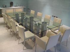 a glass dining table with white chairs around it