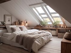 an attic bedroom with white walls and wood flooring is furnished with natural light from the windows