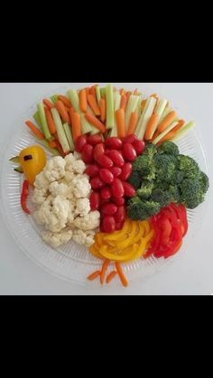 a plate filled with vegetables on top of a white table next to a rubber duck