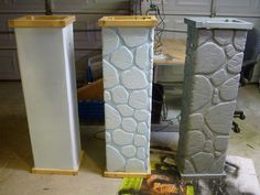 three tall white vases sitting next to each other in a garage with tools on the floor