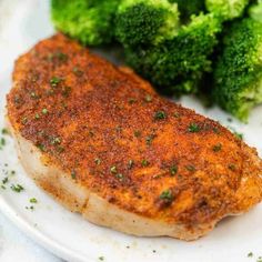 a white plate topped with meat and broccoli