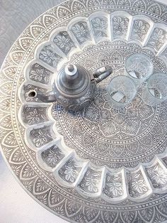 an ornate silver plate with a teapot on it